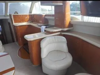 Slide: The Image of Luxurious interior of 2004 Sea Ray 480 Sedan Bridge yacht with elegant seating and kitchen area. - 15