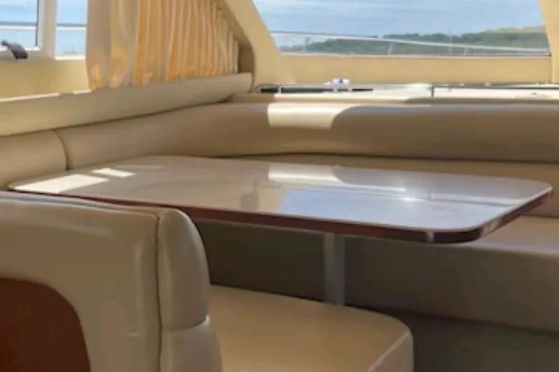 Slide: The Image of Luxurious interior of 2004 Sea Ray 480 Sedan Bridge yacht with elegant seating and table. - 18