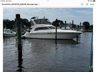 Slide: The Image of 2004 Sea Ray 480 Sedan Bridge yacht docked in a marina, calm water, clear sky. - 2