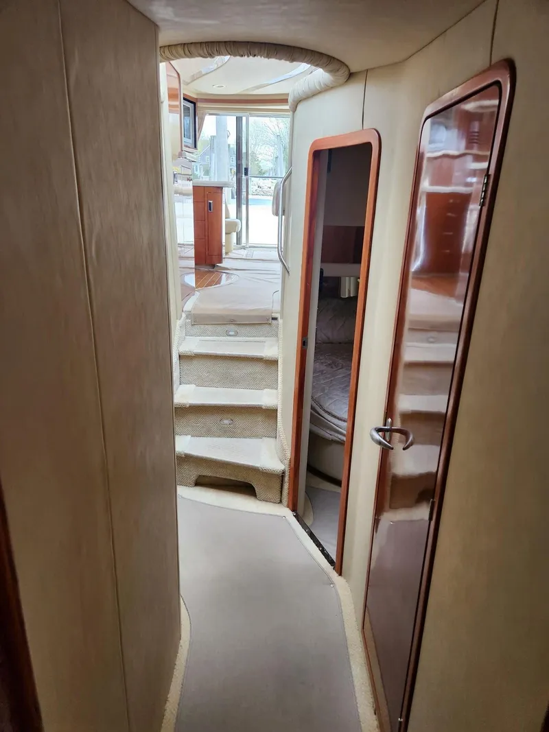 Slide: The Image of Interior hallway of 2004 Sea Ray 480 Sedan Bridge yacht, featuring stairs and cabin doors. - 31