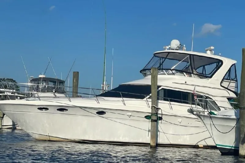 Slide: The Image of 2004 Sea Ray 480 Sedan Bridge yacht docked at marina under clear blue sky. - 4