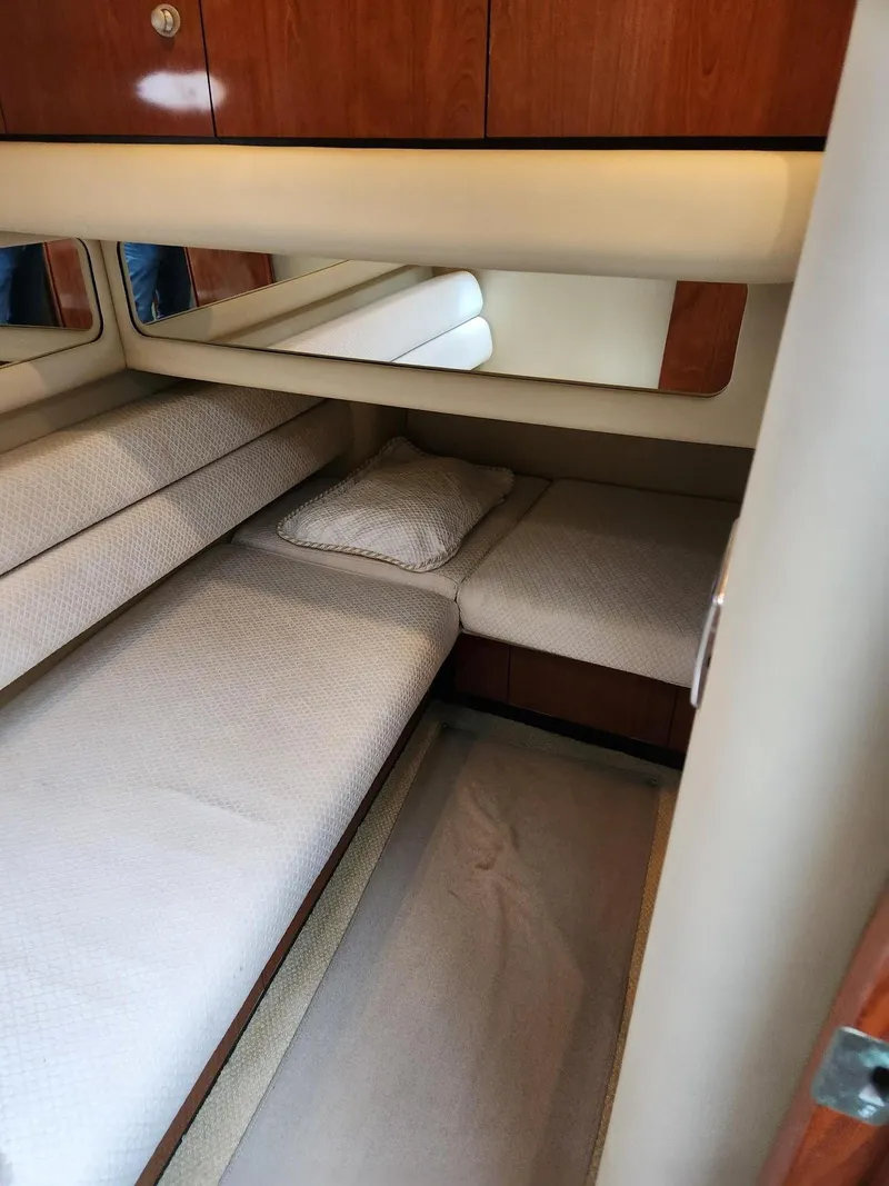 Slide: The Image of 2004 Sea Ray 480 Sedan Bridge cabin with twin beds and wooden cabinetry. - 42
