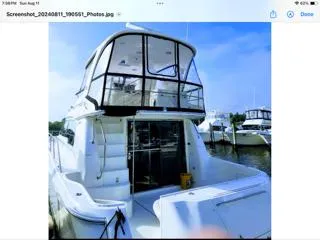 Slide: The Image of 2004 Sea Ray 480 Sedan Bridge yacht docked at marina, featuring spacious upper deck. - 5