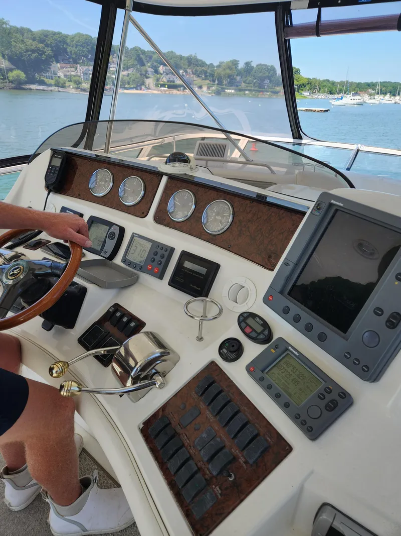 Slide: The Image of Helm of 2004 Sea Ray 480 Sedan Bridge with navigation instruments and scenic water view. - 8