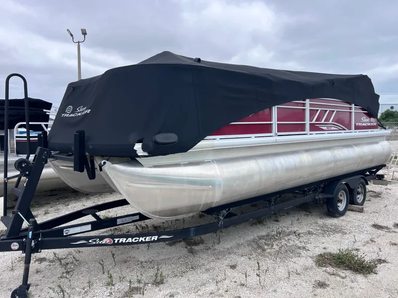 Slide: The Image of 2022 Sun Tracker Party Barge 22 RF XP3 pontoon boat on trailer, covered and parked. - 2