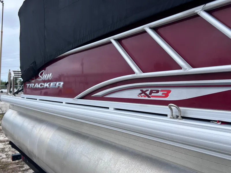 Slide: The Image of 2022 Sun Tracker Party Barge 22 RF XP3 pontoon boat, red and silver design, partially covered. - 4