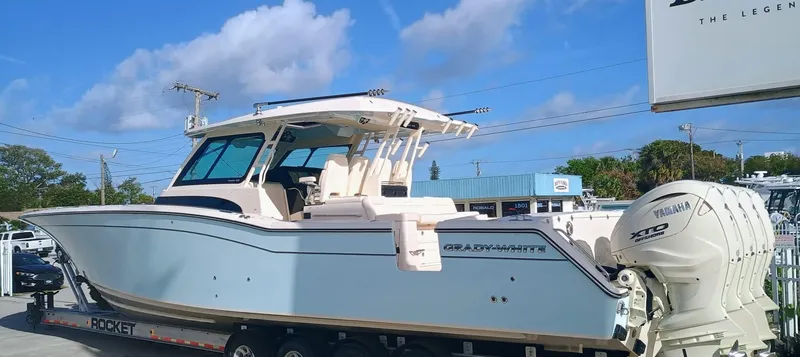 Slide: The Image of 2025 Grady-White Canyon 456 boat with Yamaha XTO engines, displayed outdoors. - 2