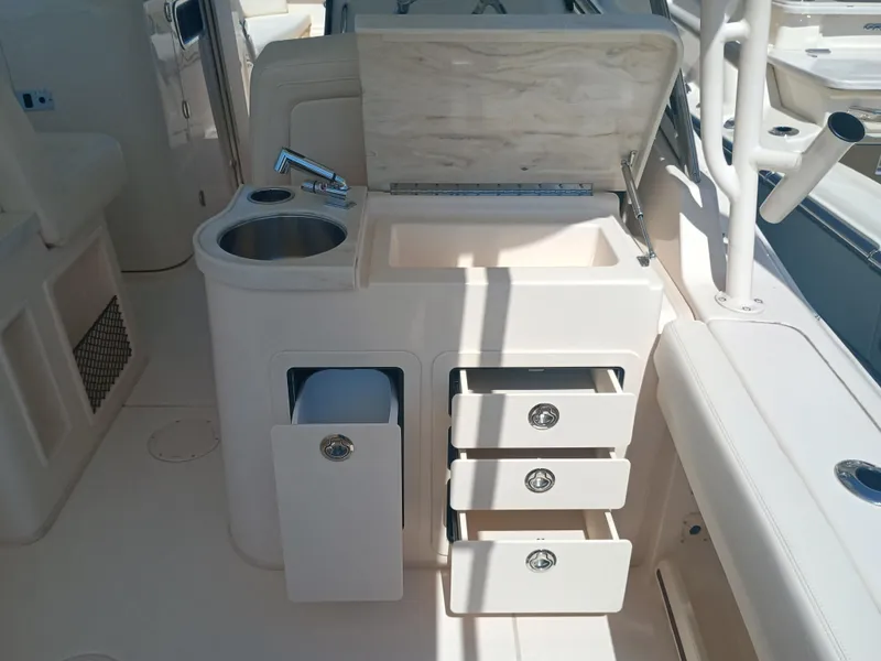 Slide: The Image of 2025 Grady-White Canyon 456 boat interior with sink, storage drawers, and countertop. - 27
