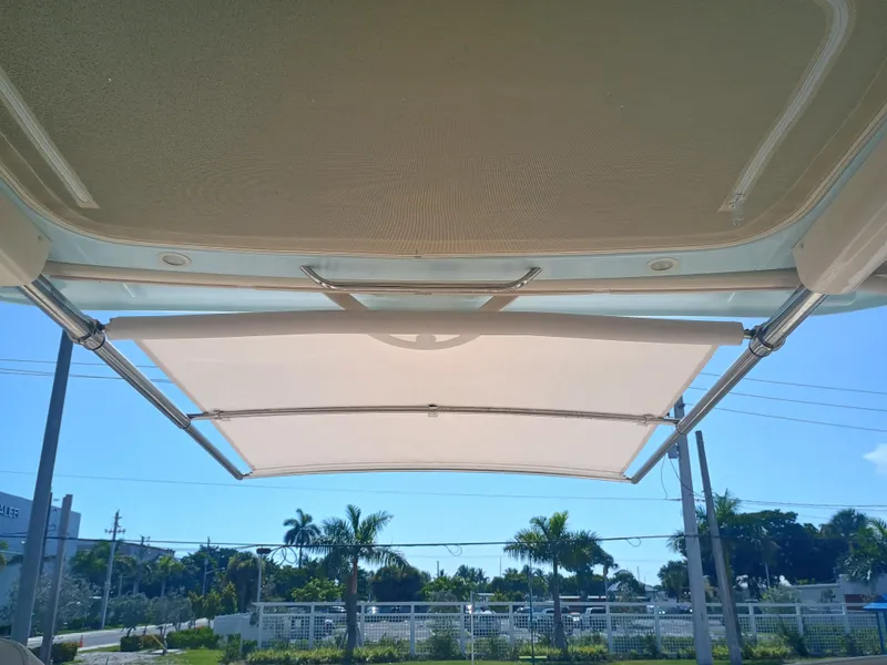 Slide: The Image of 2025 Grady-White Canyon 456 boat canopy with clear sky and palm trees in background. - 38