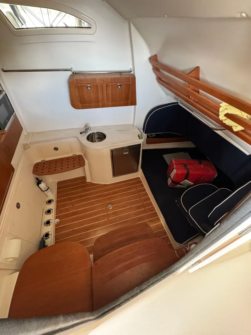 Slide: The Image of 2023 Grady-White Canyon 376 cabin interior with wood accents and seating area. - 11