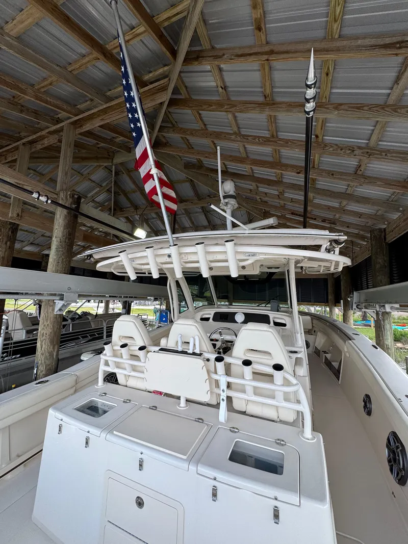 Slide: The Image of 2023 Grady-White Canyon 376 boat under a wooden roof with American flag. - 15