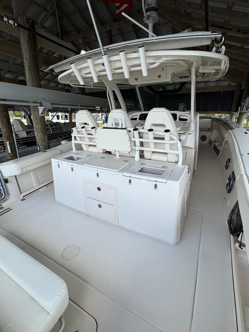 Slide: The Image of 2023 Grady-White Canyon 376 boat interior with seating and storage under a canopy. - 18