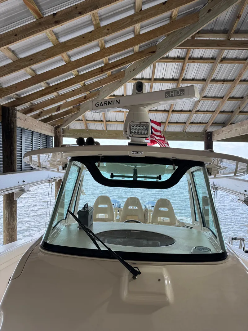 Slide: The Image of 2023 Grady-White Canyon 376 boat under a wooden dock with Garmin equipment. - 22