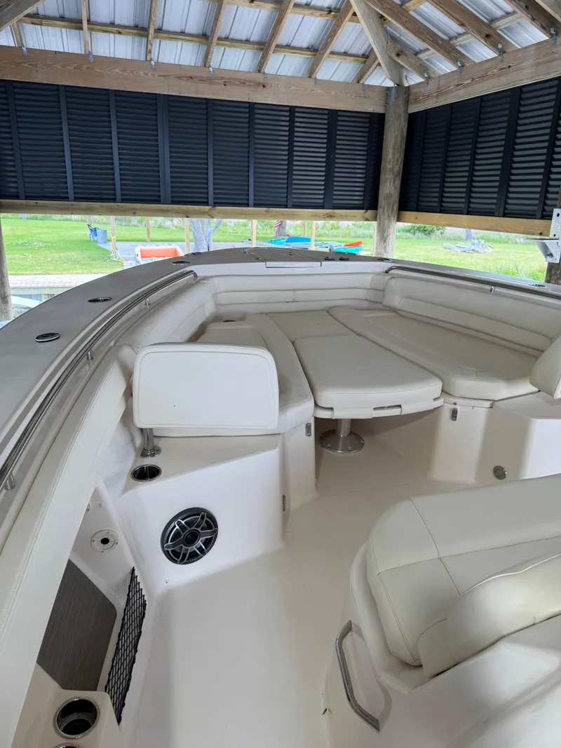 Slide: The Image of 2023 Grady-White Canyon 376 boat interior with white seating under a wooden canopy. - 25