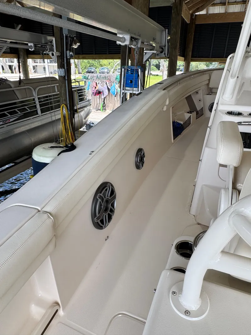 Slide: The Image of 2023 Grady-White Canyon 376 boat interior with seating and speakers in a dock setting. - 5
