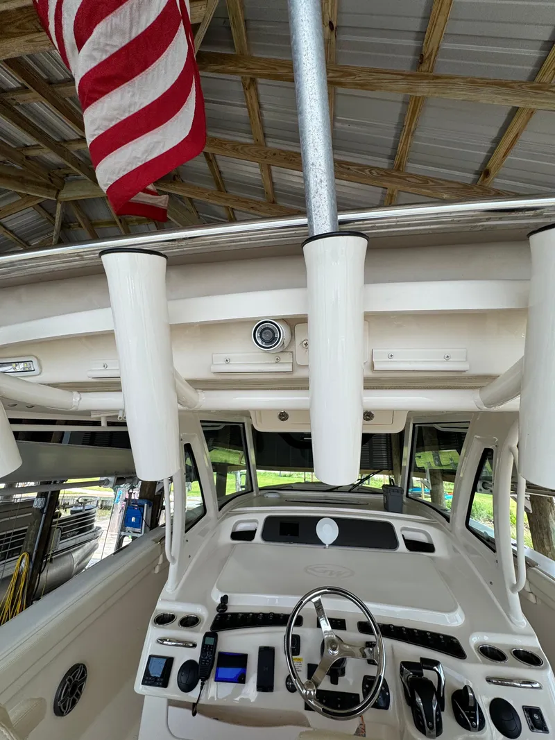 Slide: The Image of 2023 Grady-White Canyon 376 boat helm with American flag, under a wooden roof. - 6