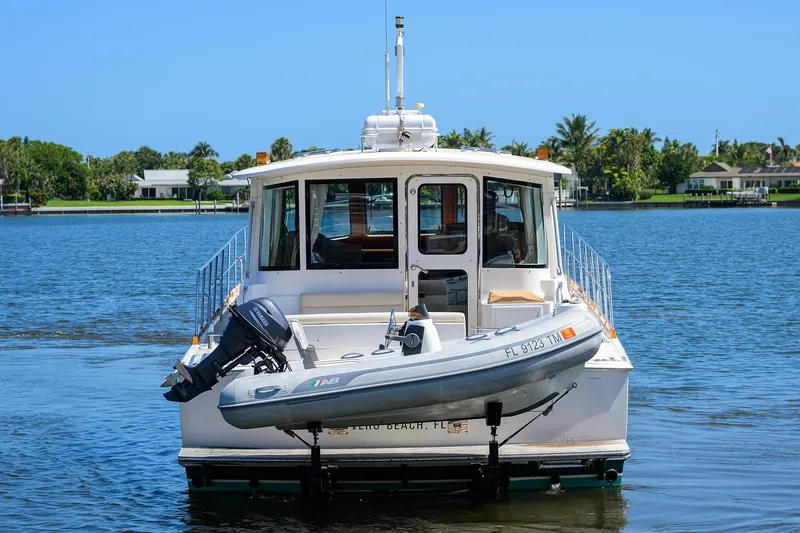 Slide: The Image of 2014 Grand Banks 46 Eastbay SX yacht with dinghy on calm water. - 12