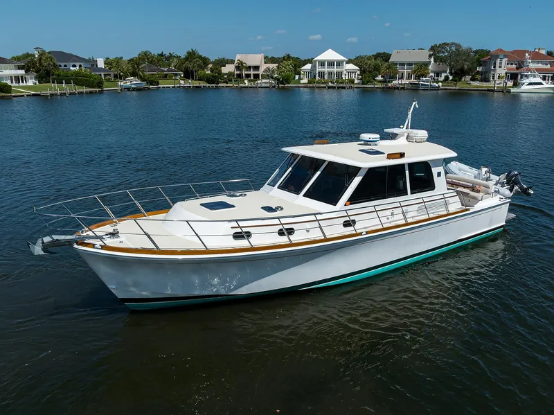 Slide: The Image of 2014 Grand Banks 46 Eastbay SX yacht on calm water near waterfront homes. - 16