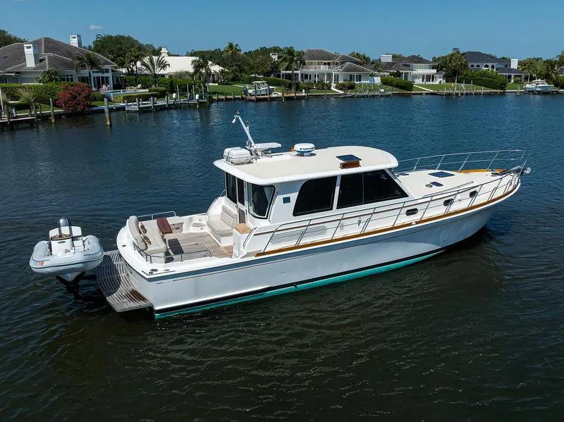 Slide: The Image of 2014 Grand Banks 46 Eastbay SX yacht on calm water near waterfront homes. - 20