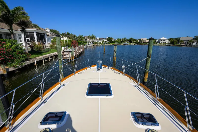 Slide: The Image of Bow view of 2014 Grand Banks 46 Eastbay SX yacht docked in a serene marina. - 23
