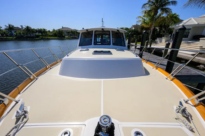 Slide: The Image of 2014 Grand Banks 46 Eastbay SX yacht docked by palm trees and waterfront homes. - 25