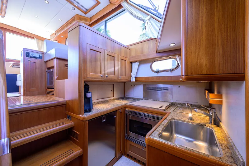 Slide: The Image of Luxurious 2014 Grand Banks 46 Eastbay SX yacht interior with modern kitchen and wooden cabinetry. - 3