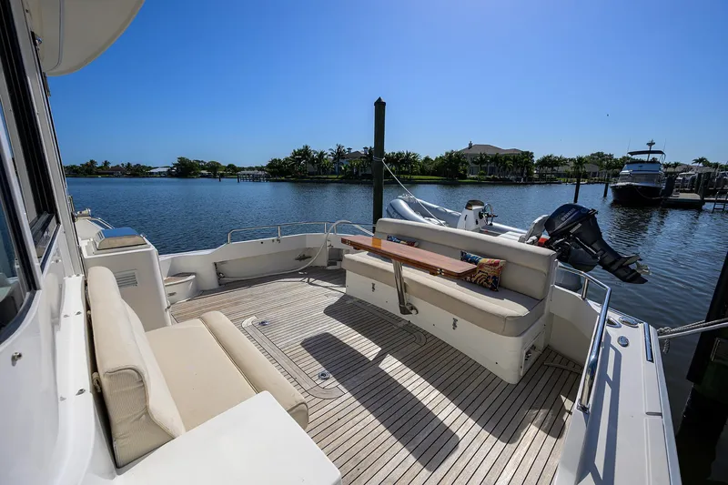 Slide: The Image of 2014 Grand Banks 46 Eastbay SX yacht deck with seating, overlooking serene waterfront. - 33