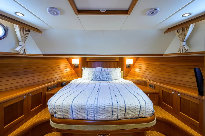 Slide: The Image of Luxurious cabin interior of 2014 Grand Banks 46 Eastbay SX yacht with wood paneling and cozy bed. - 4
