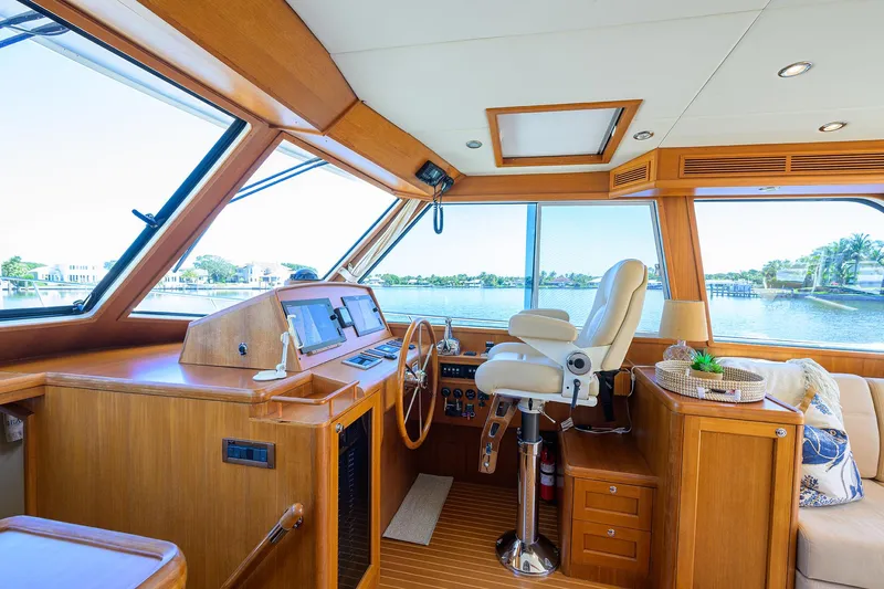 Slide: The Image of 2014 Grand Banks 46 Eastbay SX yacht interior with helm, wooden finish, and panoramic windows. - 51