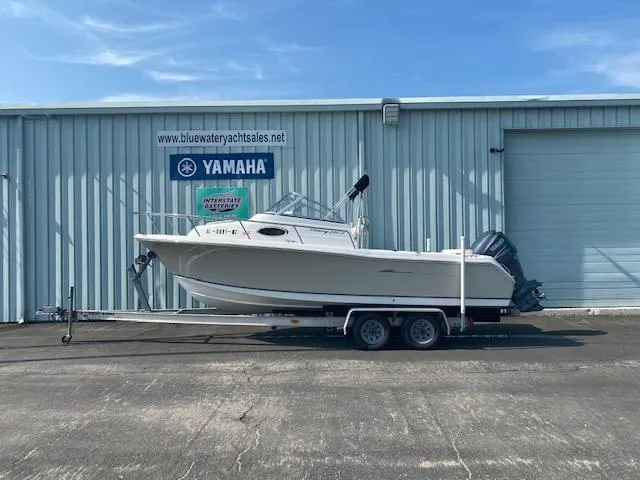 Slide: The Image of 2010 Sea Hunt 225 Victory LE boat on trailer outside Yamaha dealership. - 1