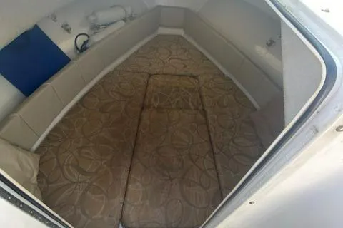 Slide: The Image of 2010 Sea Hunt 225 Victory LE cabin interior with patterned cushions and storage space. - 12