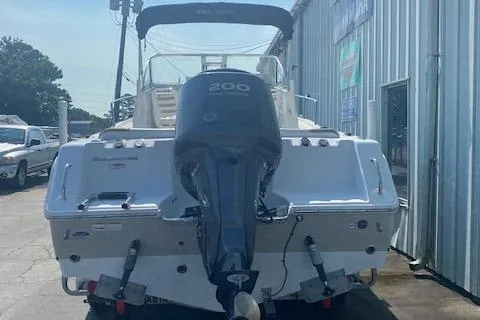 Slide: The Image of 2010 Sea Hunt 225 Victory LE boat with outboard motor, parked near a metal building. - 7