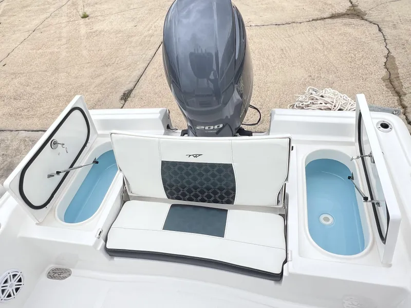 Slide: The Image of 2023 Tidewater 2210 Carolina Bay boat with open storage compartments and outboard motor. - 5