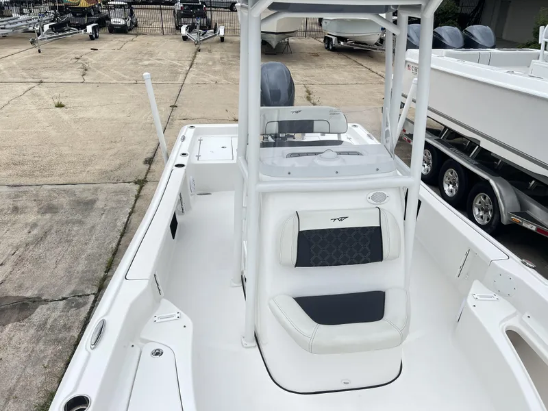Slide: The Image of 2023 Tidewater 2210 Carolina Bay boat interior with seating and console, parked on concrete. - 6