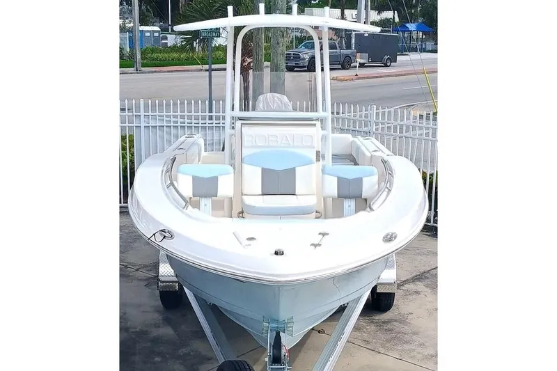 Slide: The Image of 2025 Robalo R202 Explorer boat on trailer, parked near a street. - 5