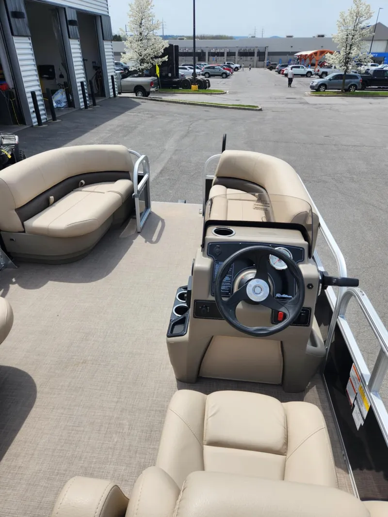 Slide: The Image of 2025 Sun Tracker Party Barge 16 DLX pontoon boat with beige seating and steering console. - 3