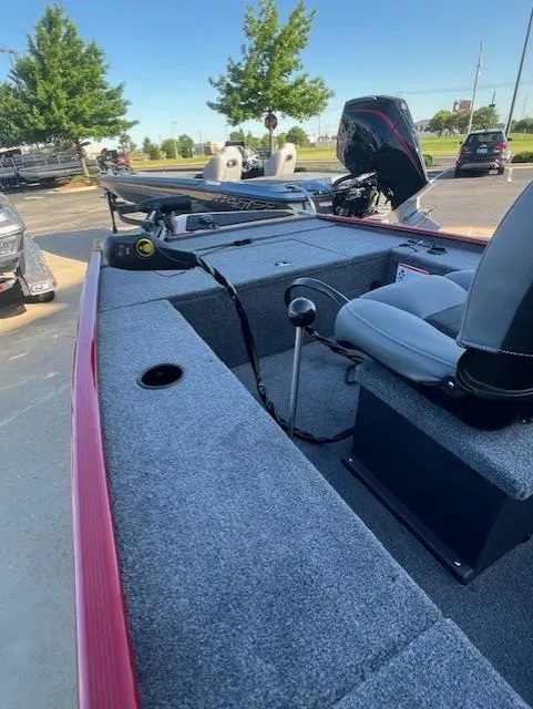 Slide: The Image of 2025 Tracker Panfish 17 boat with seating and control panel, parked outdoors. - 2