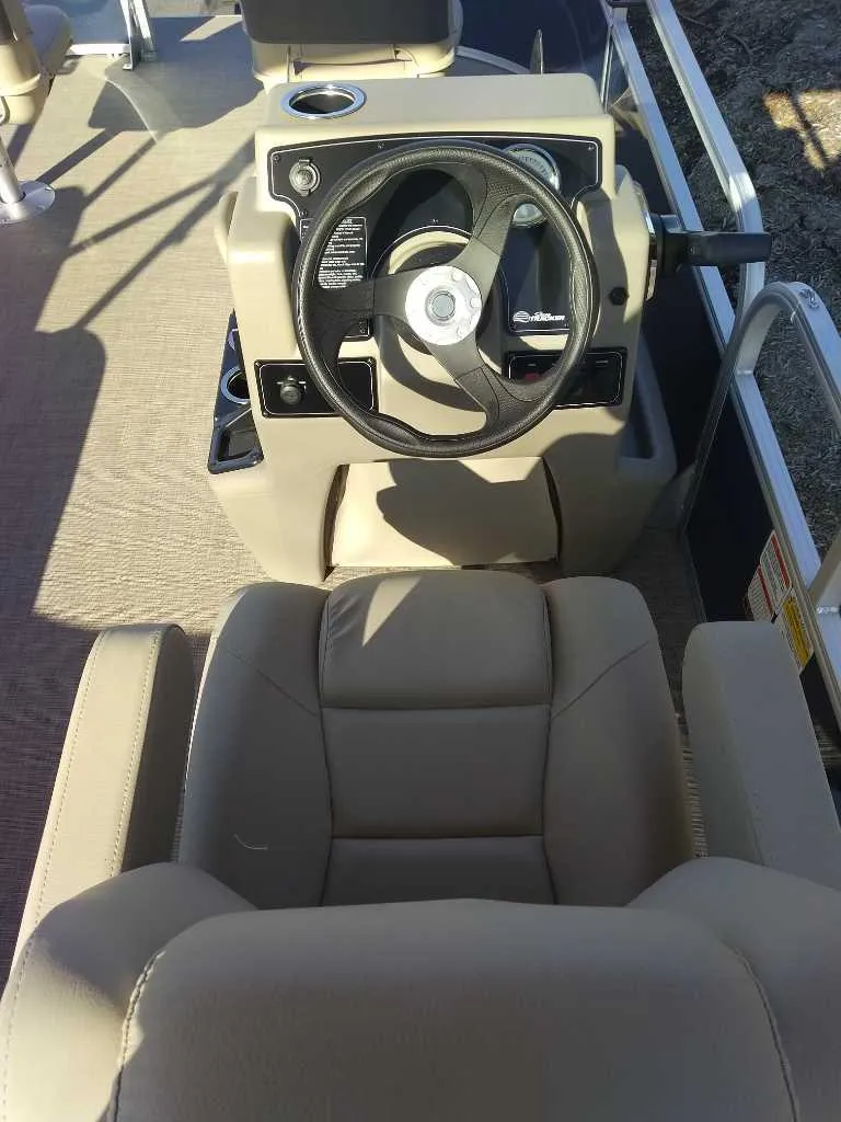 Slide: The Image of 2025 Sun Tracker Bass Buggy 18 DLX boat interior with steering wheel and seating. - 2