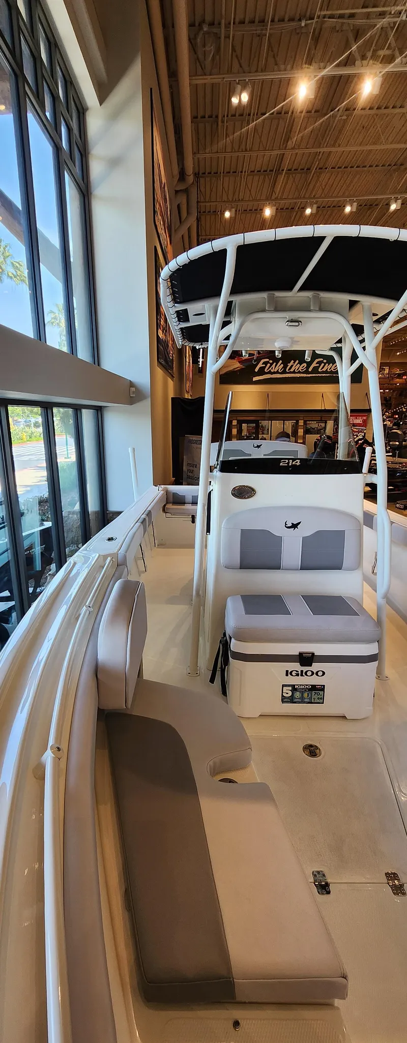 Slide: The Image of 2025 Mako 214 CC boat interior with seating and console, displayed indoors. - 1