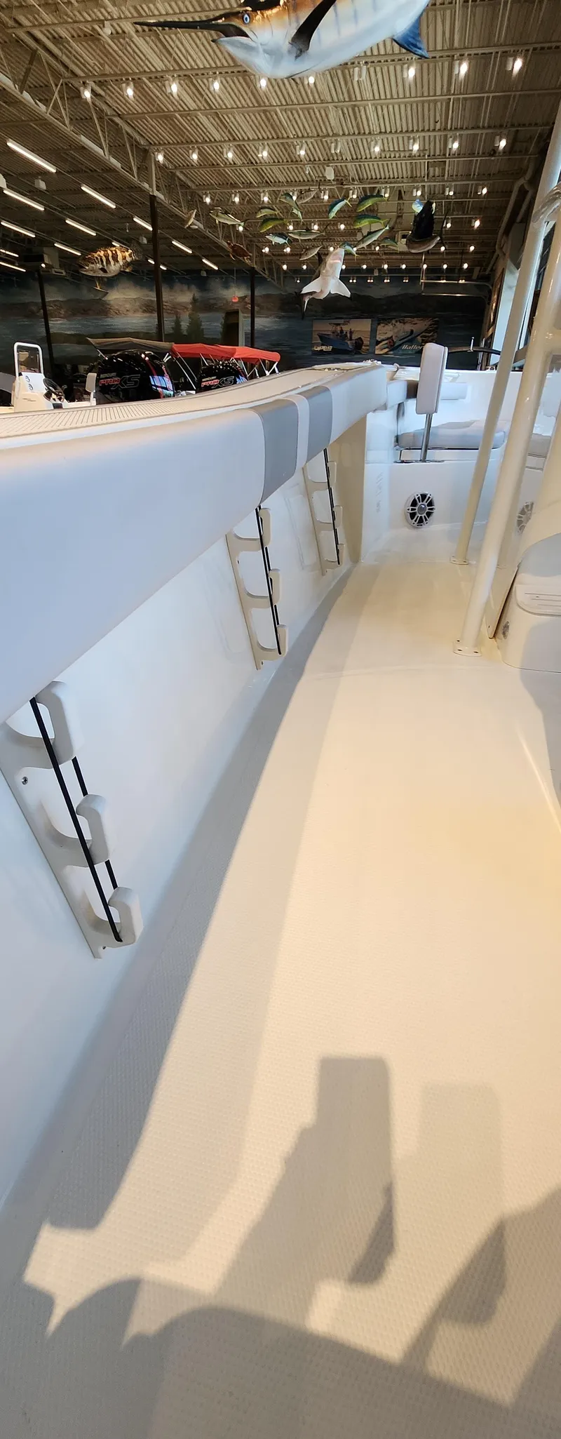 Slide: The Image of 2025 Mako 214 CC boat interior with sleek white design in a showroom setting. - 7