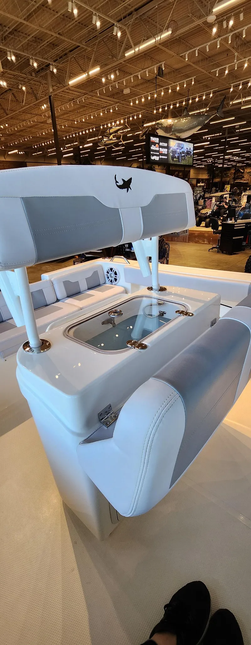 Slide: The Image of 2025 Mako 214 CC boat interior with seating and storage, displayed in a showroom. - 9