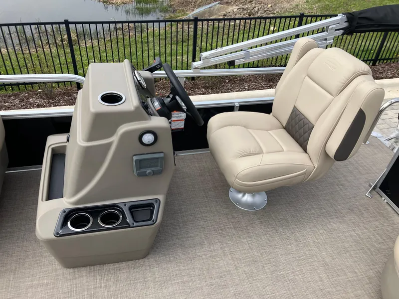 Slide: The Image of 2025 Sun Tracker Party Barge 16 DLX helm with beige captain's chair and console. - 5