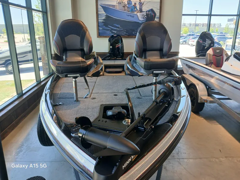 Slide: The Image of 2025 Ranger Z518 boat with dual seats and trolling motor in showroom display. - 14
