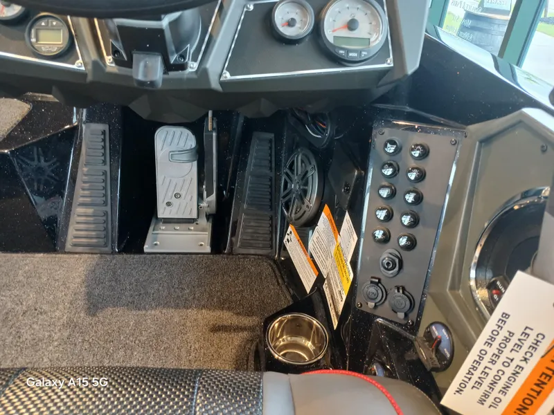 Slide: The Image of Interior view of 2025 Ranger Z518 boat dashboard with controls and foot pedals. - 18
