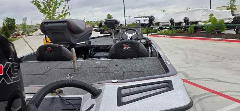 Slide: The Image of 2025 Ranger Z518 boat interior with seating and steering wheel, parked outdoors. - 6