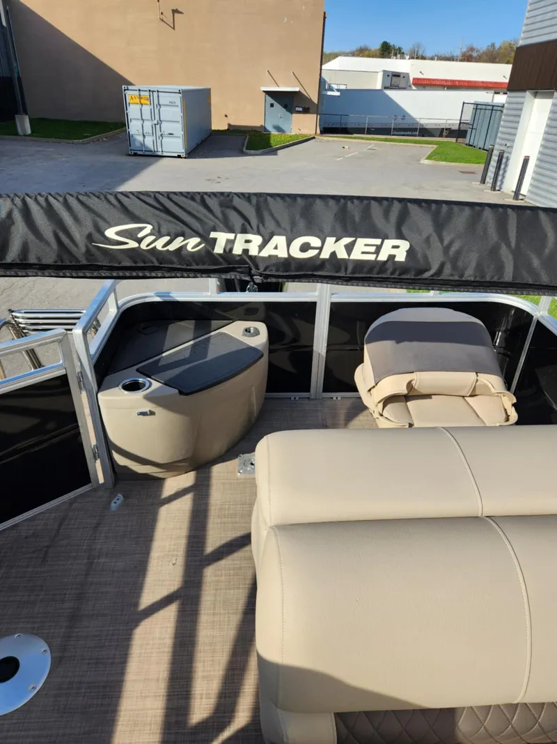 Slide: The Image of 2025 Sun Tracker SportFish 20 DLX pontoon boat interior with beige seating and storage. - 3