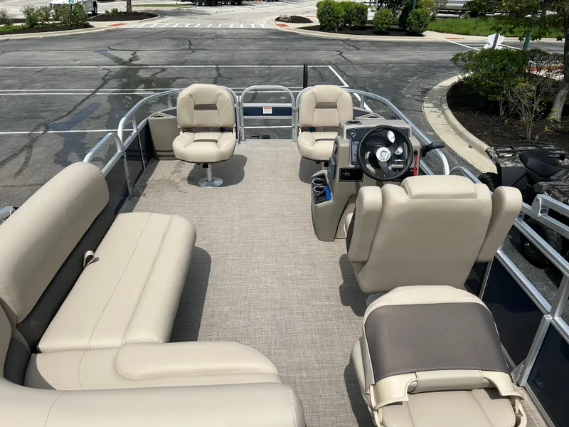 Slide: The Image of 2025 Sun Tracker Bass Buggy 18 DLX pontoon boat with beige seating and steering console. - 2
