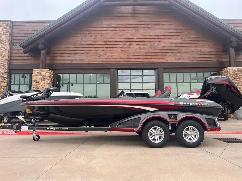 The Image of 2025 Ranger Z519R boat on trailer, parked outside a wooden building. - 0