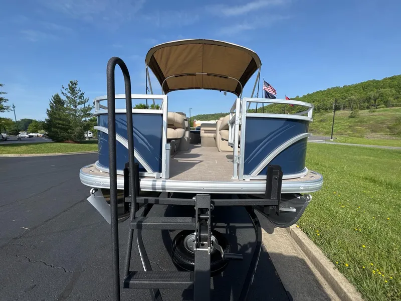 Slide: The Image of 2025 Sun Tracker Fishin' Barge 20 DLX pontoon boat on trailer, parked outdoors. - 4