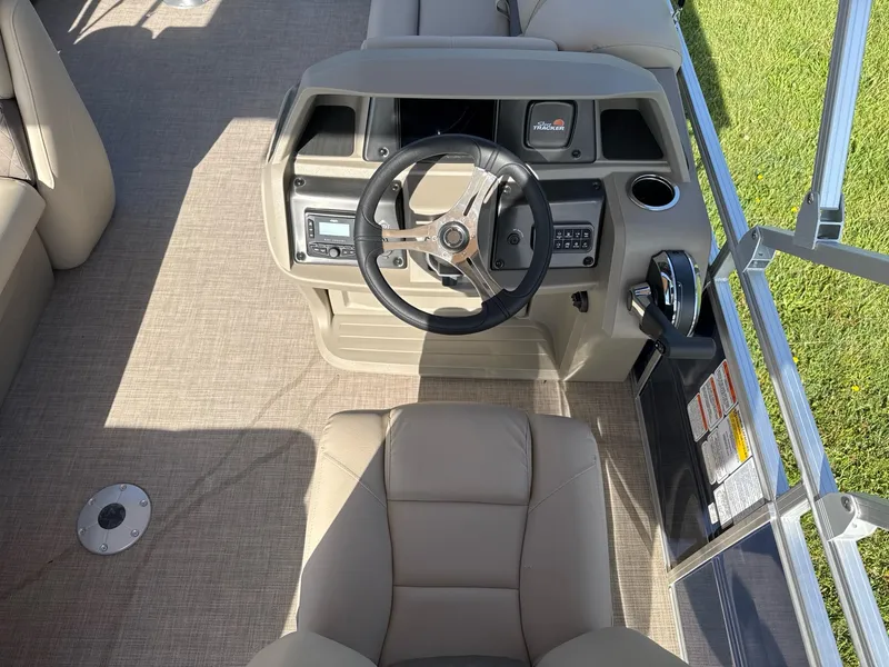 Slide: The Image of 2025 Sun Tracker Fishin' Barge 20 DLX helm with steering wheel and control panel. - 7